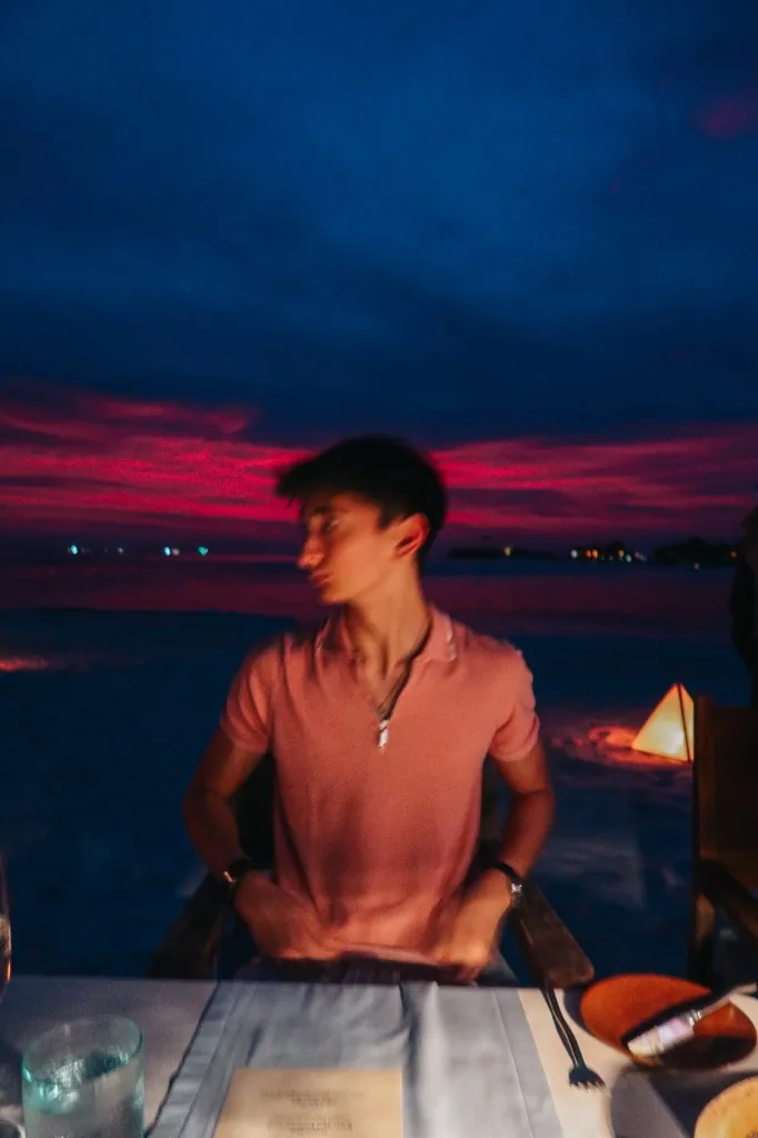 Enzo Deligny enjoying a sunset dinner with a scenic view